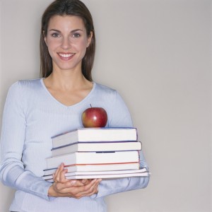Smiling Teacher Carrying Textbooks and Apple