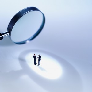 Close-up of magnifying glass focusing on two people --- Image by © Royalty-Free/Corbis